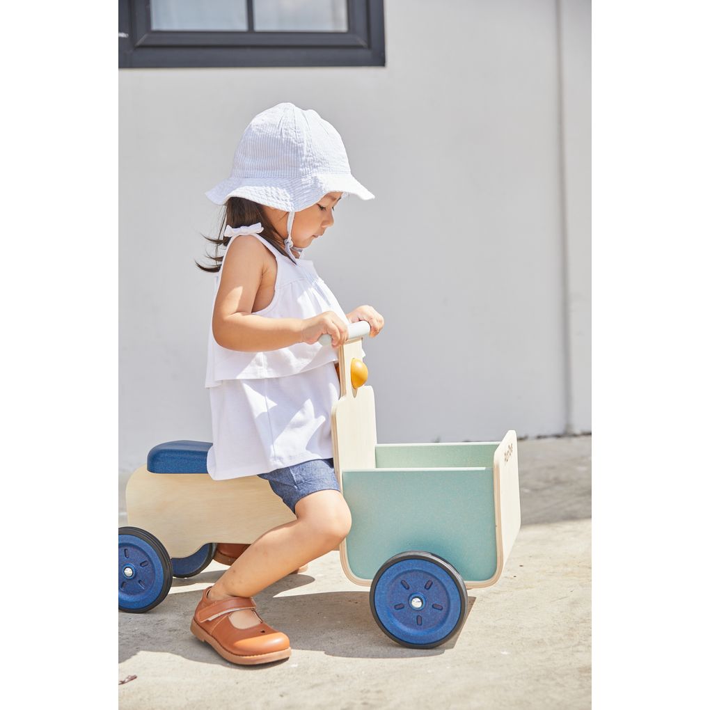 Kid playing PlanToys Delivery Bike - Orchard Collection เด็กกำลังเล่นรถส่งของขาไถแปลนทอยส์