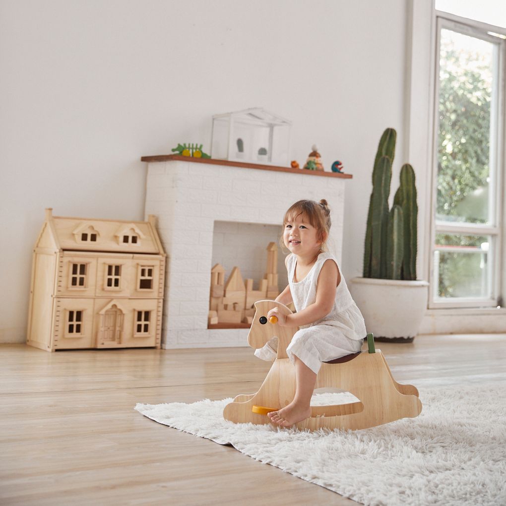 Kid playing PlanToys Palomino - Modern Rustic เด็กกำลังเล่นม้าโยกพาโลมิโนแปลนทอยส์