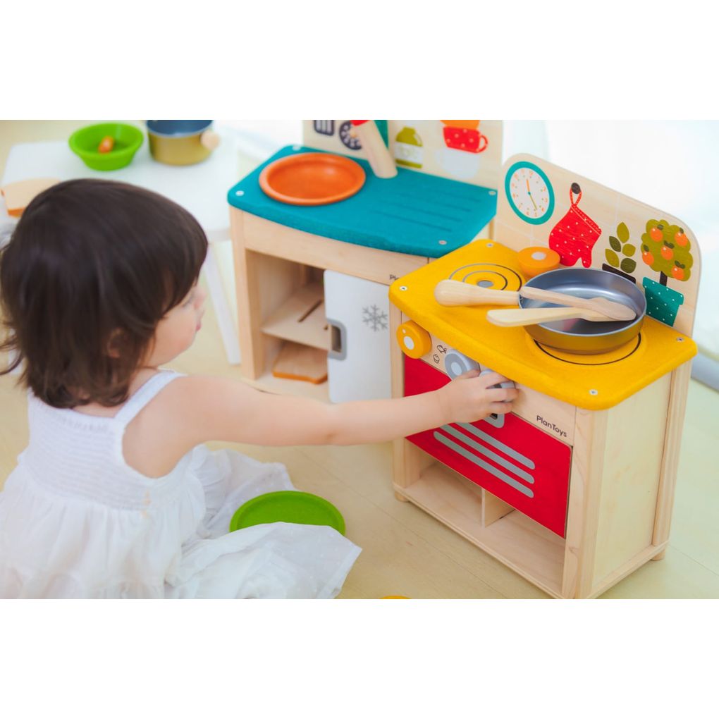 Kid playing PlanToys Kitchen Set เด็กกำลังเล่นชุดครัวมินิแปลนทอยส์