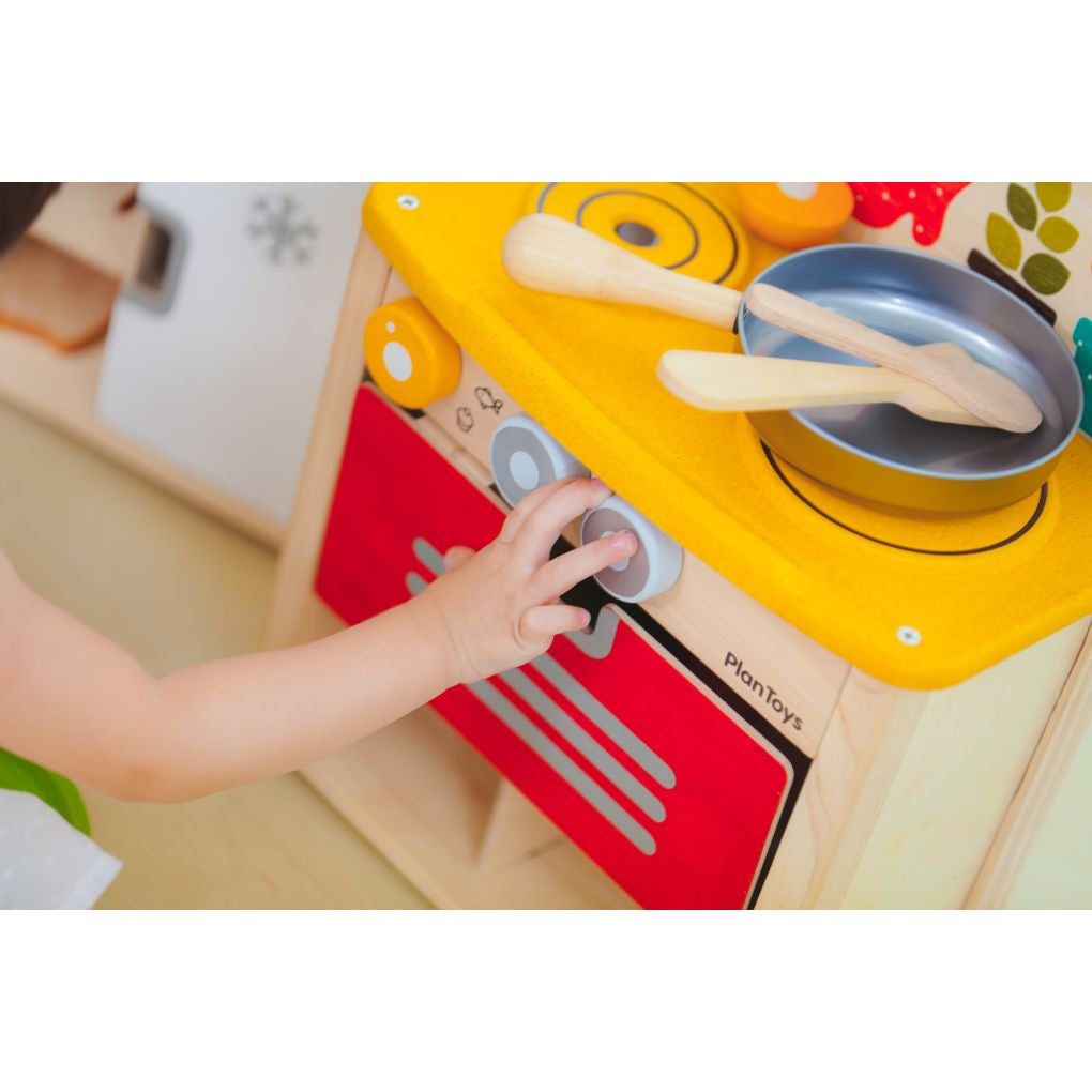 Kid playing PlanToys Kitchen Set เด็กกำลังเล่นชุดครัวมินิแปลนทอยส์