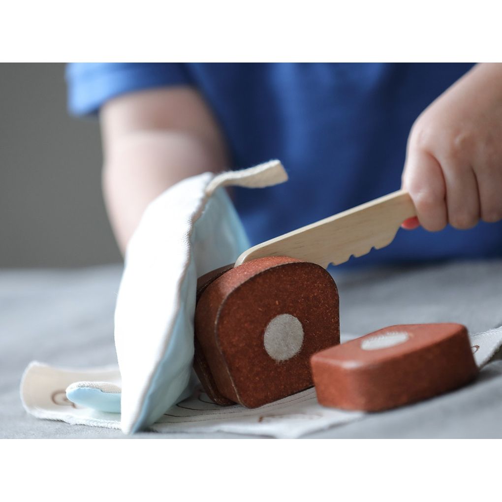 Kid playing PlanToys Bread Loaf Set เด็กกำลังเล่นชุดอบขนมปังแปลนทอยส์