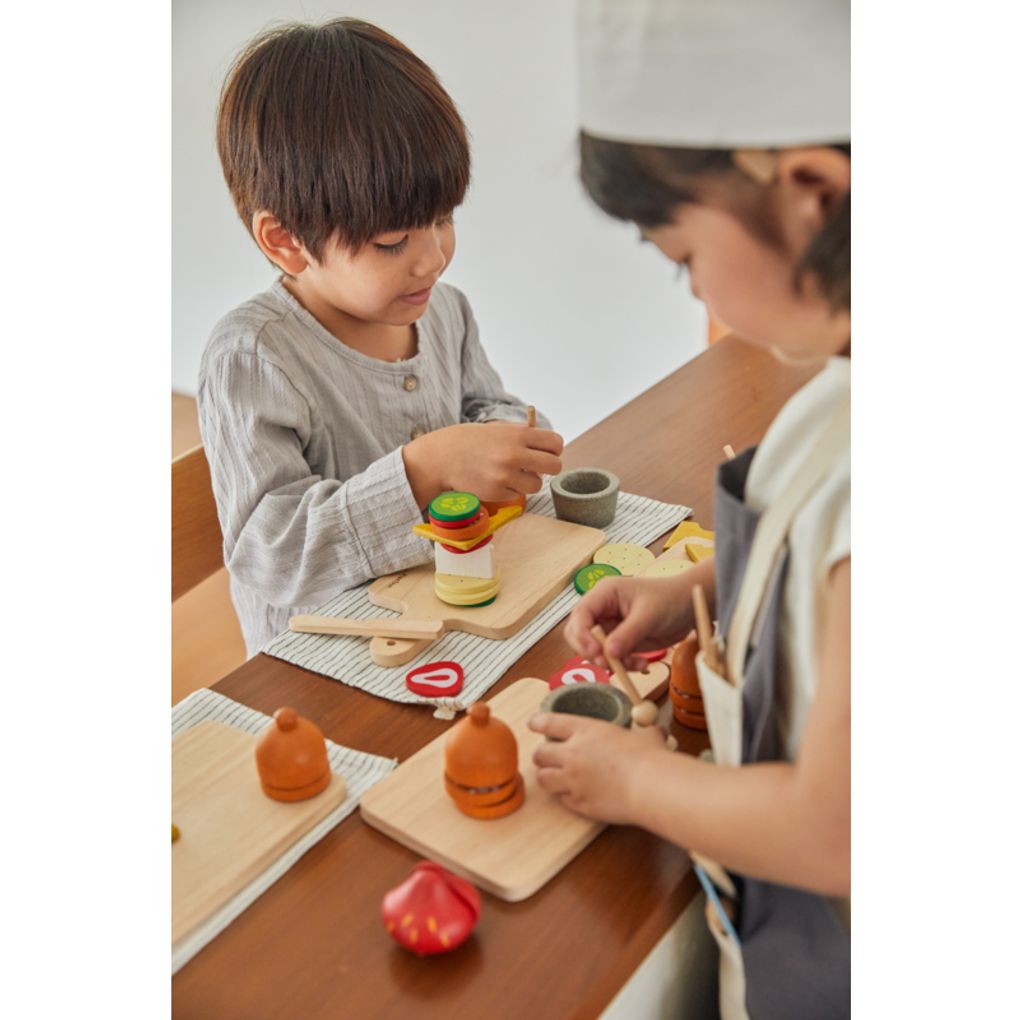 Kid playing PlanToys Cheese & Charcuterie Board เด็กกำลังเล่นชีสแอนด์ชาร์คูเตอรีบอร์ดแปลนทอยส์