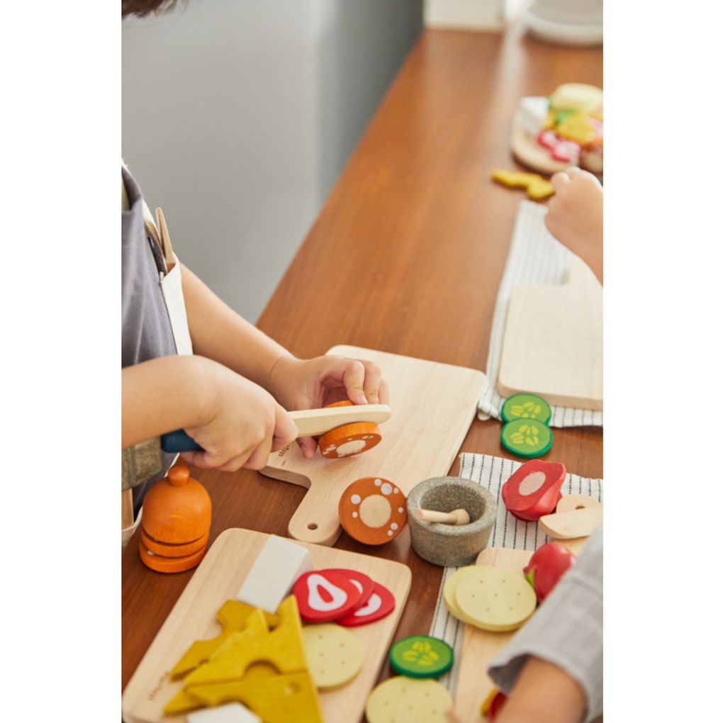 Kid playing PlanToys Cheese & Charcuterie Board เด็กกำลังเล่นชีสแอนด์ชาร์คูเตอรีบอร์ดแปลนทอยส์