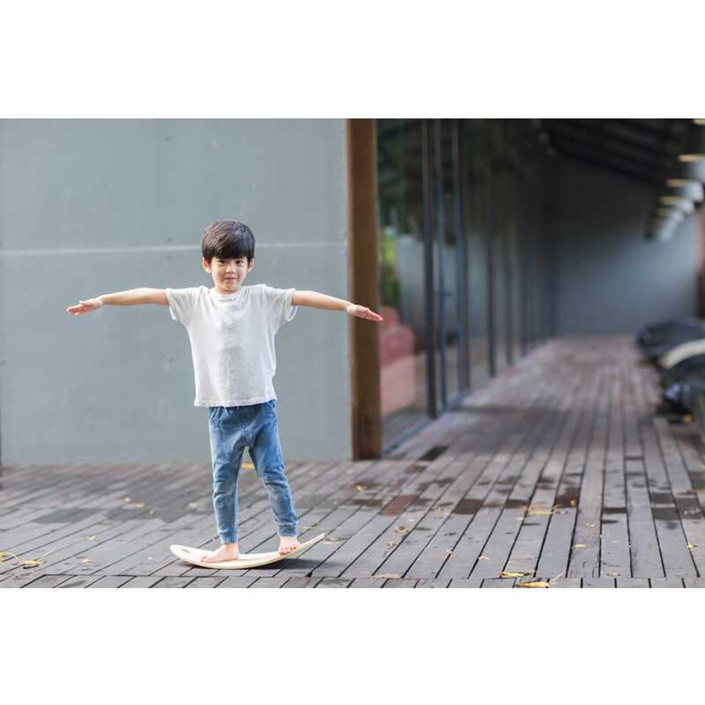 Kid playing PlanToys Balance Board เด็กกำลังเล่นกระดานทรงตัวแปลนทอยส์