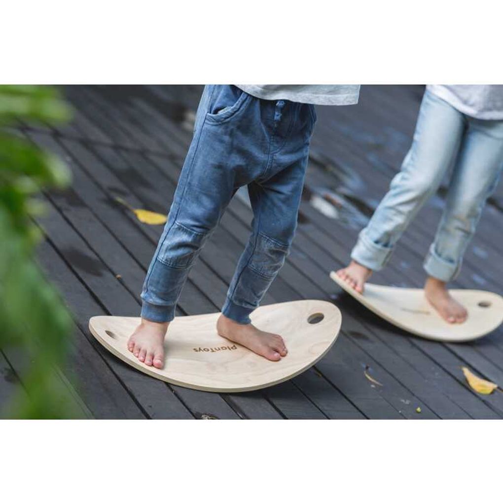 Kid playing PlanToys Balance Board เด็กกำลังเล่นกระดานทรงตัวแปลนทอยส์