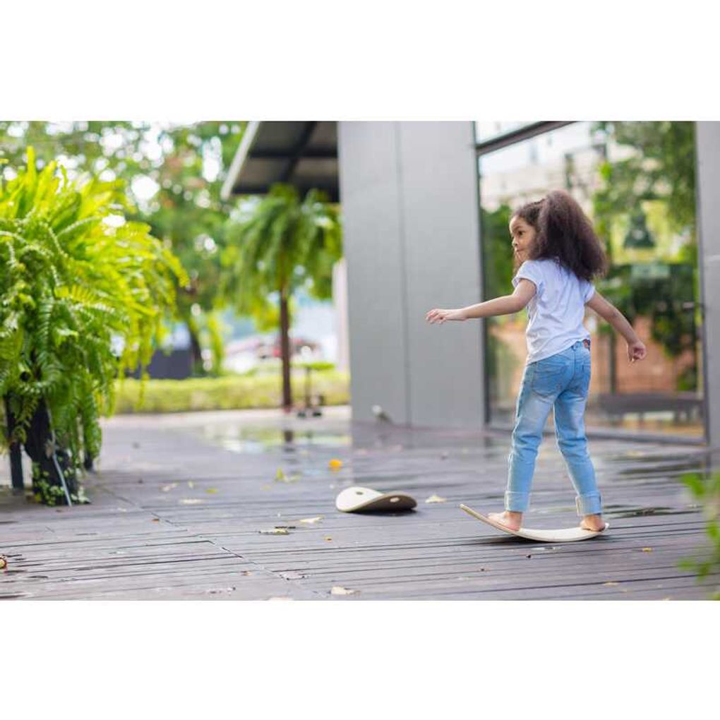 Kid playing PlanToys Balance Board เด็กกำลังเล่นกระดานทรงตัวแปลนทอยส์