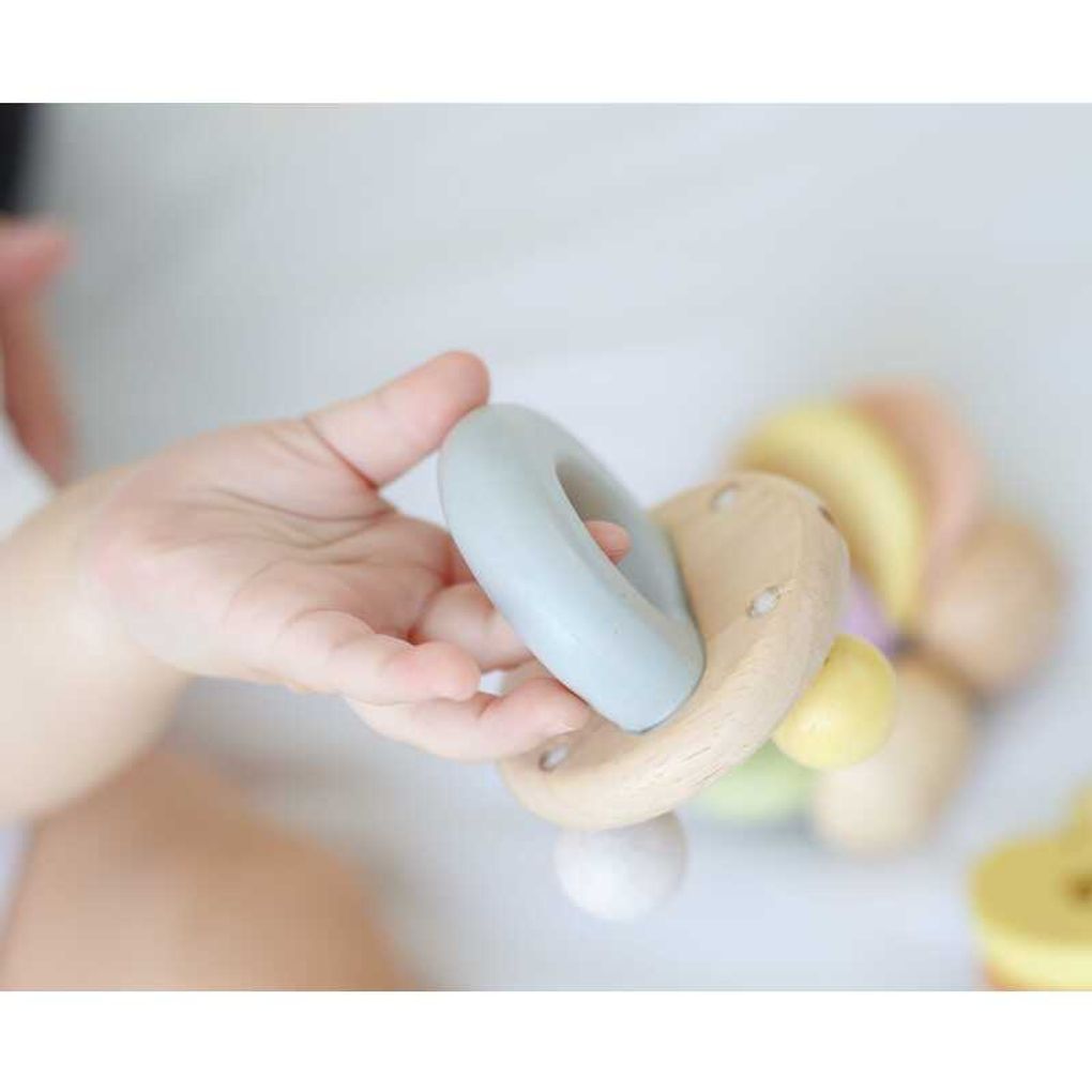 Kid playing PlanToys Bell Rattle - Pastel Series เด็กทารกกำลังเล่นกระดิ่งไม้แปลนทอยส์