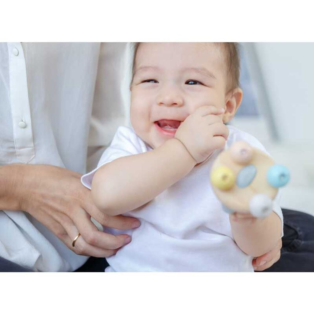 Kid playing PlanToys Bell Rattle - Pastel Series เด็กทารกกำลังเล่นกระดิ่งไม้แปลนทอยส์