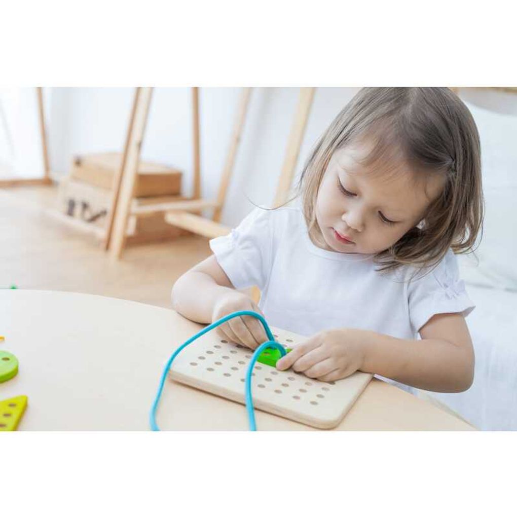 Kid playing PlanToys Lacing Board เด็กกำลังเล่นบอร์ดไม้ร้อยเชือกแปลนทอยส์