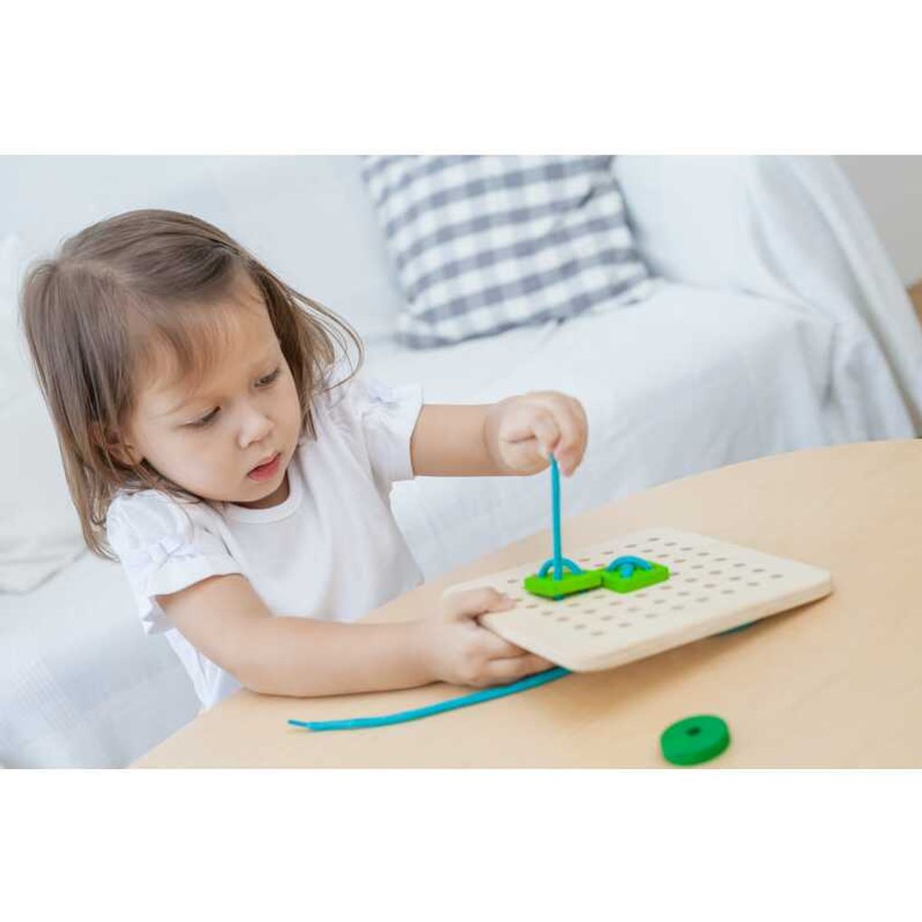 Kid playing PlanToys Lacing Board เด็กกำลังเล่นบอร์ดไม้ร้อยเชือกแปลนทอยส์