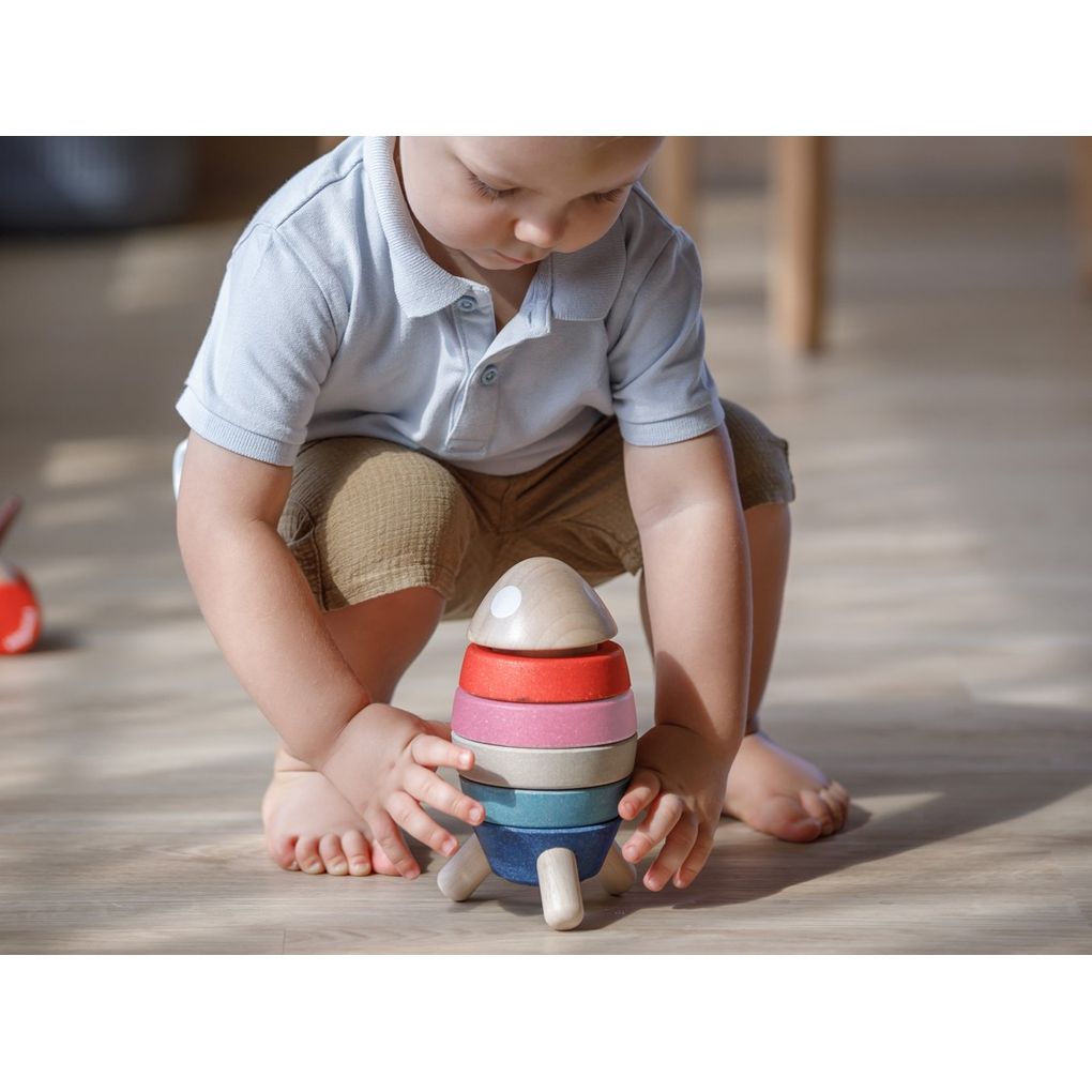 Kid playing PlanToys Stacking Rocket - Orchard Series เด็กกำลังเล่นจรวดเรียงซ้อนแปลนทอยส์