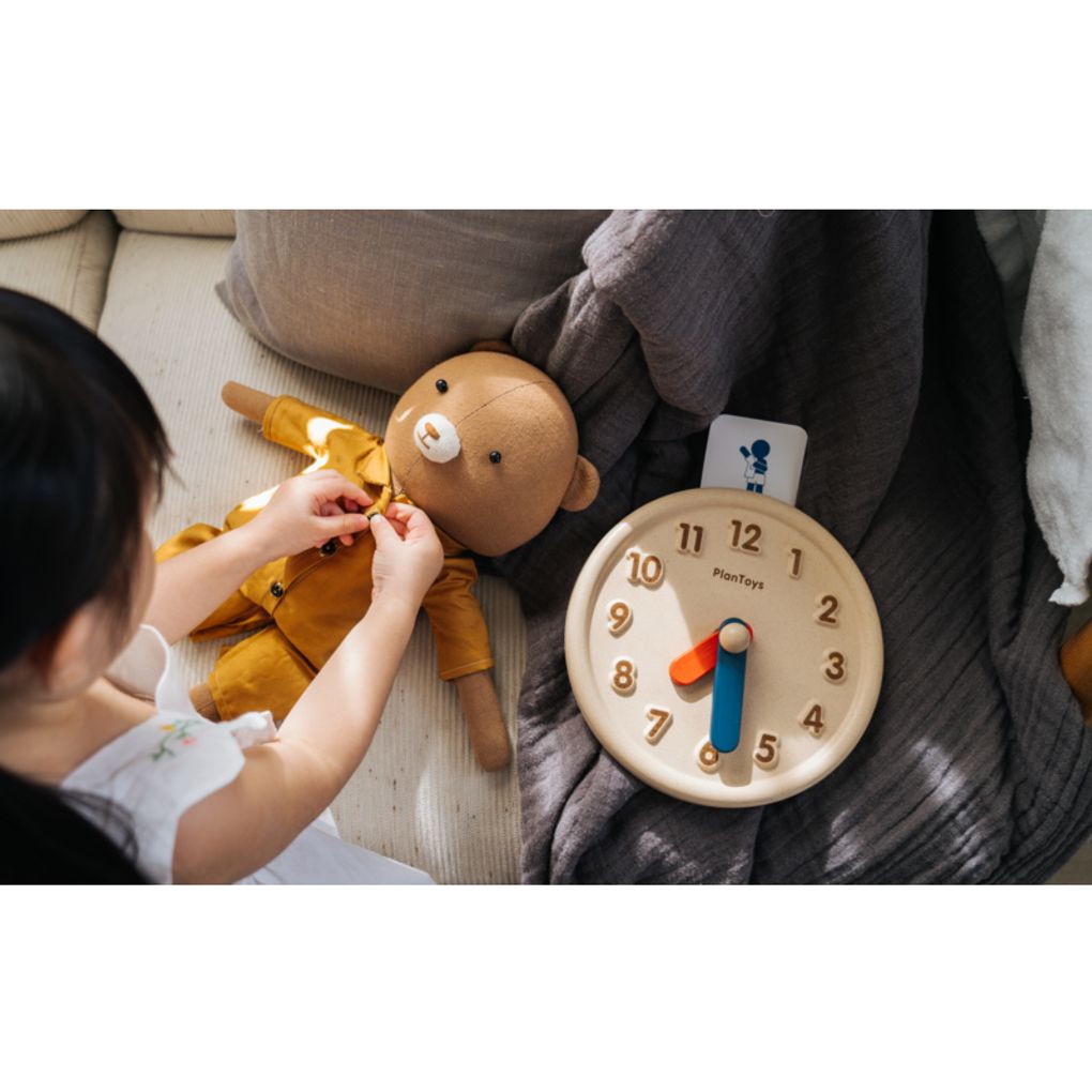 Kid playing PlanToys Activity Clock เด็กกำลังเล่นนาฬิกากิจวัตรประจำวันแปลนทอยส์