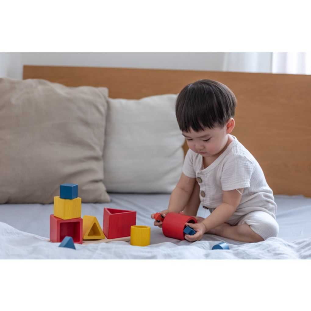 Kid playing PlanToys Nesting Puzzle - Unit Plus เด็กกำลังเล่นชุดเรขาคณิตเรียงซ้อน-ยูนิตพลัสแปลนทอยส์