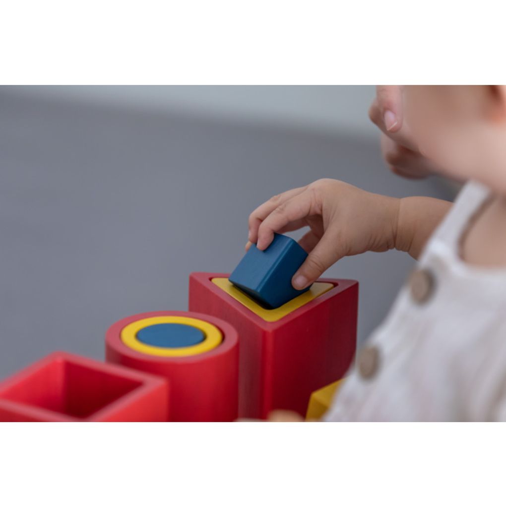 Kid playing PlanToys Nesting Puzzle - Unit Plus เด็กกำลังเล่นชุดเรขาคณิตเรียงซ้อน-ยูนิตพลัสแปลนทอยส์