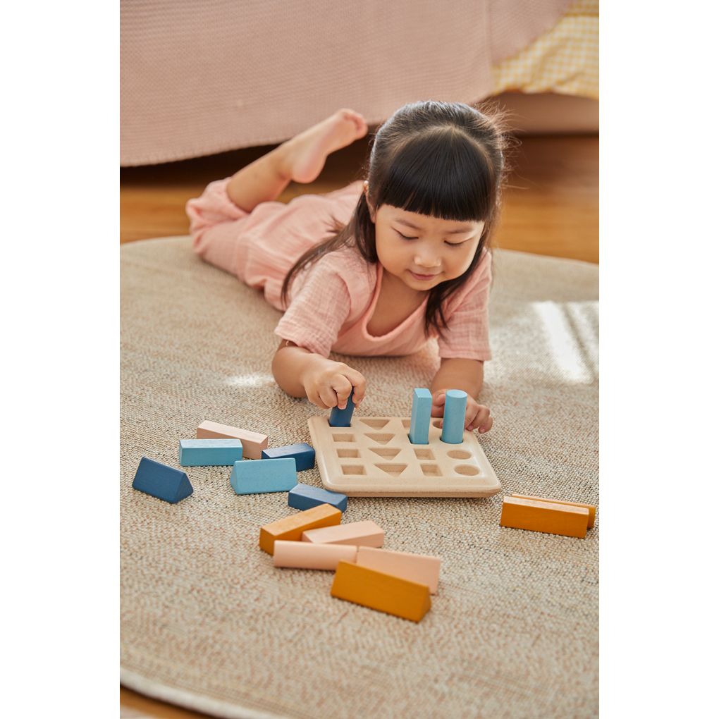 Kid playing PlanToys Geometric Peg Board - Orchard เด็กกำลังเล่น
กระดานแท่งหมุดเรขาคณิต-ออชาร์ดแปลนทอยส์