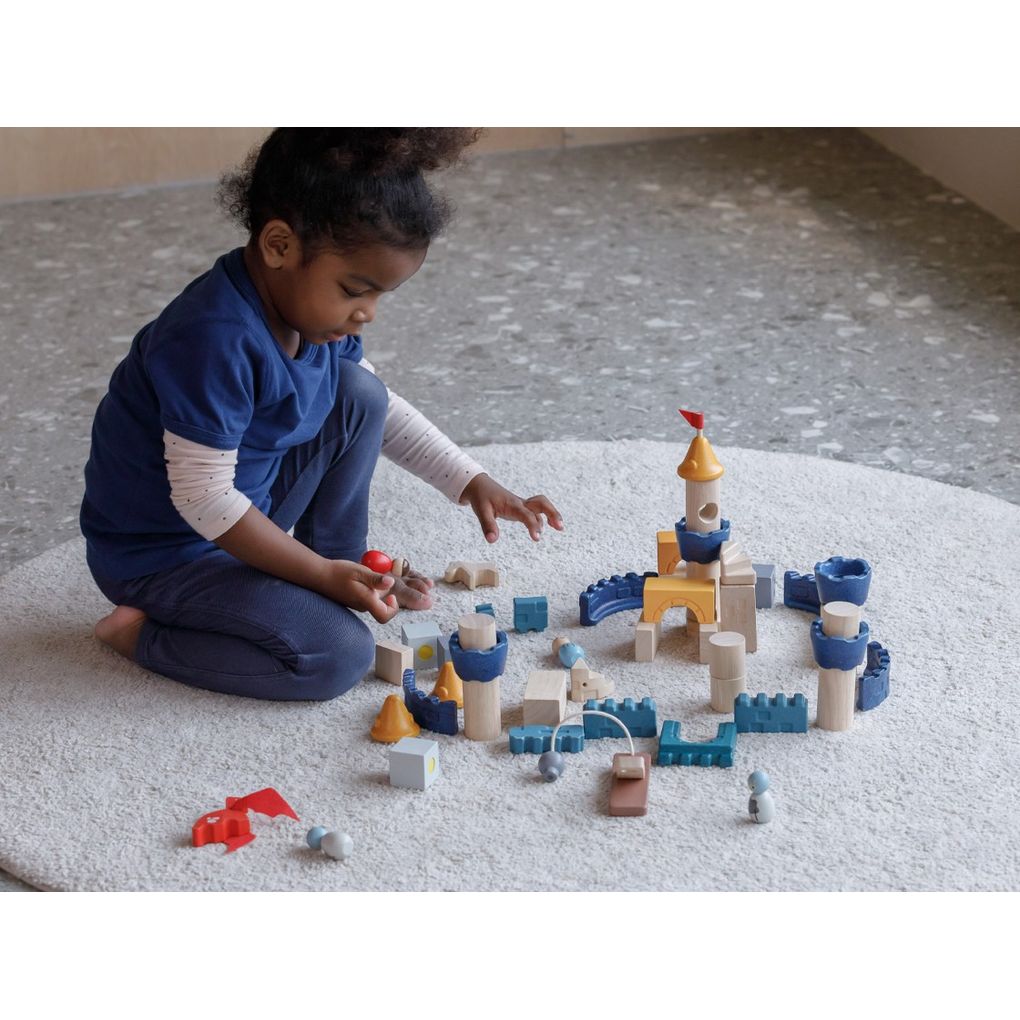 Kid playing PlanToys Castle Blocks - Orchard Series เด็กกำลังเล่นปราสาทอัศวินแปลนทอยส์