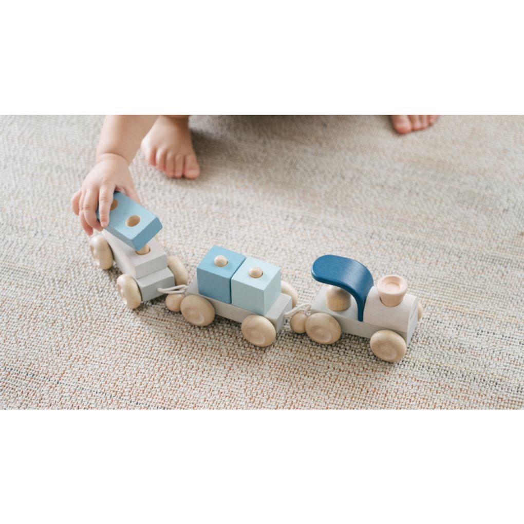 Kid playing PlanToys Stacking Train Trio - Orchard เด็กกำลังเล่นรถไฟต่อบล็อก-ออชาร์ดแปลนทอยส์