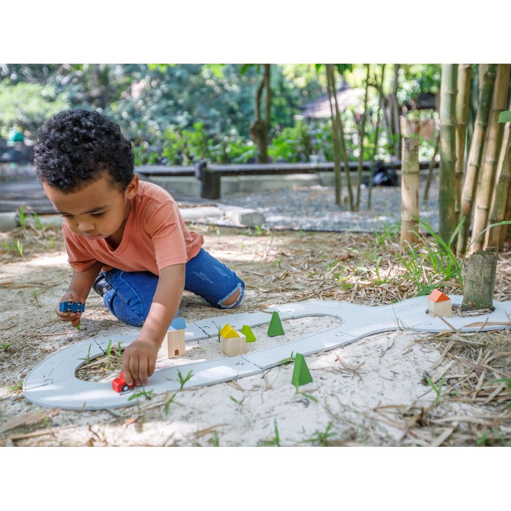 Kid playing PlanToys Rubber Road & Rail Set - Medium เด็กกำลังเล่นชุดถนนและรางรถไฟยาง-กลางแปลนทอยส์