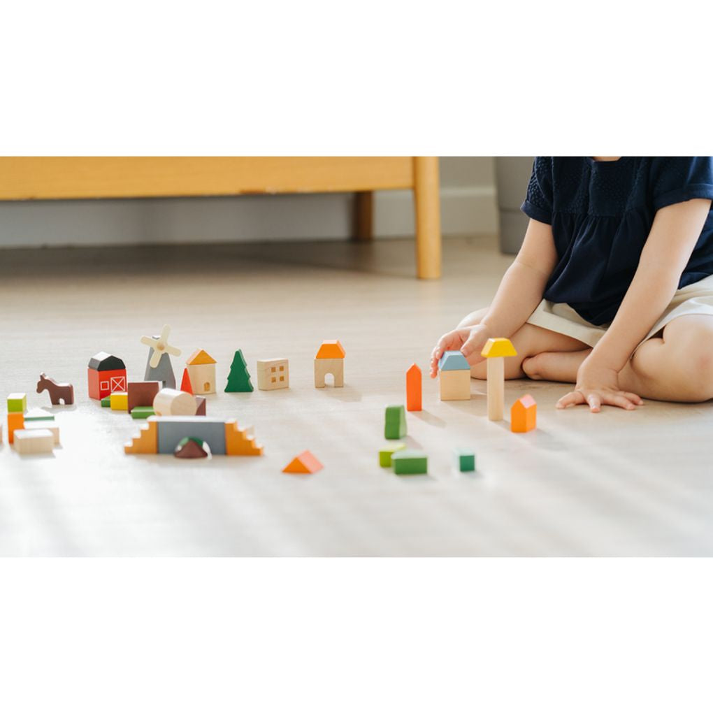 Kid playing PlanToys Countryside Blocks เด็กกำลังเล่นชุดบล็อกหมู่บ้านชนบทแปลนทอยส์