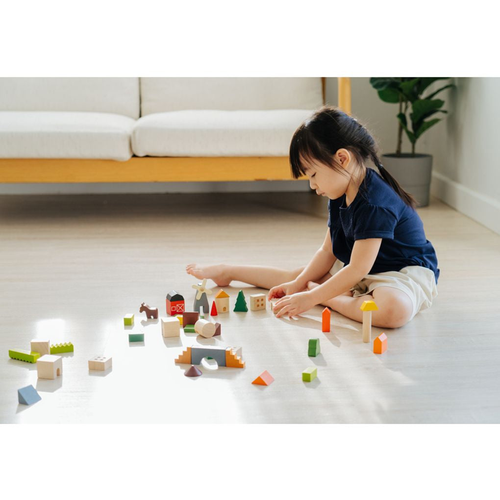 Kid playing PlanToys Countryside Blocks เด็กกำลังเล่นชุดบล็อกหมู่บ้านชนบทแปลนทอยส์