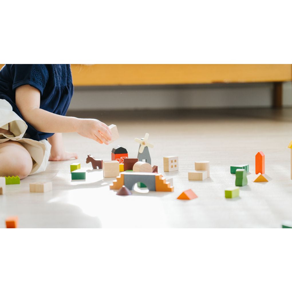 Kid playing PlanToys Countryside Blocks เด็กกำลังเล่นชุดบล็อกหมู่บ้านชนบทแปลนทอยส์