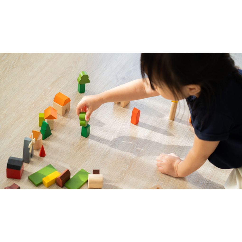 Kid playing PlanToys Countryside Blocks เด็กกำลังเล่นชุดบล็อกหมู่บ้านชนบทแปลนทอยส์