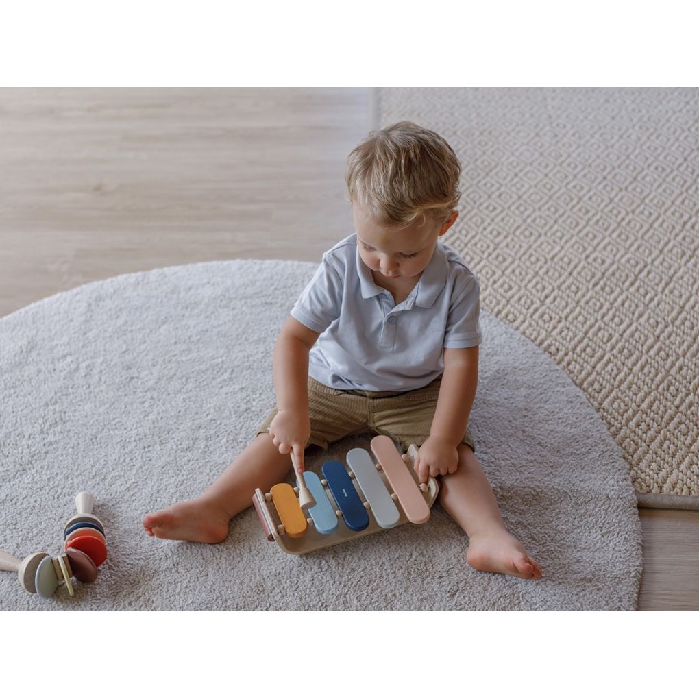 Kid playing PlanToys Oval Xylophone - Orchard Series เด็กกำลังเล่นระนาดแปลนทอยส์