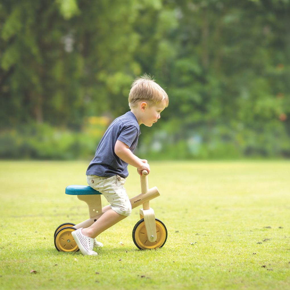 Kid playing PlanToys Balance Tricycle เด็กกำลังเล่นรถจักรยานขาไถแปลนทอยส์