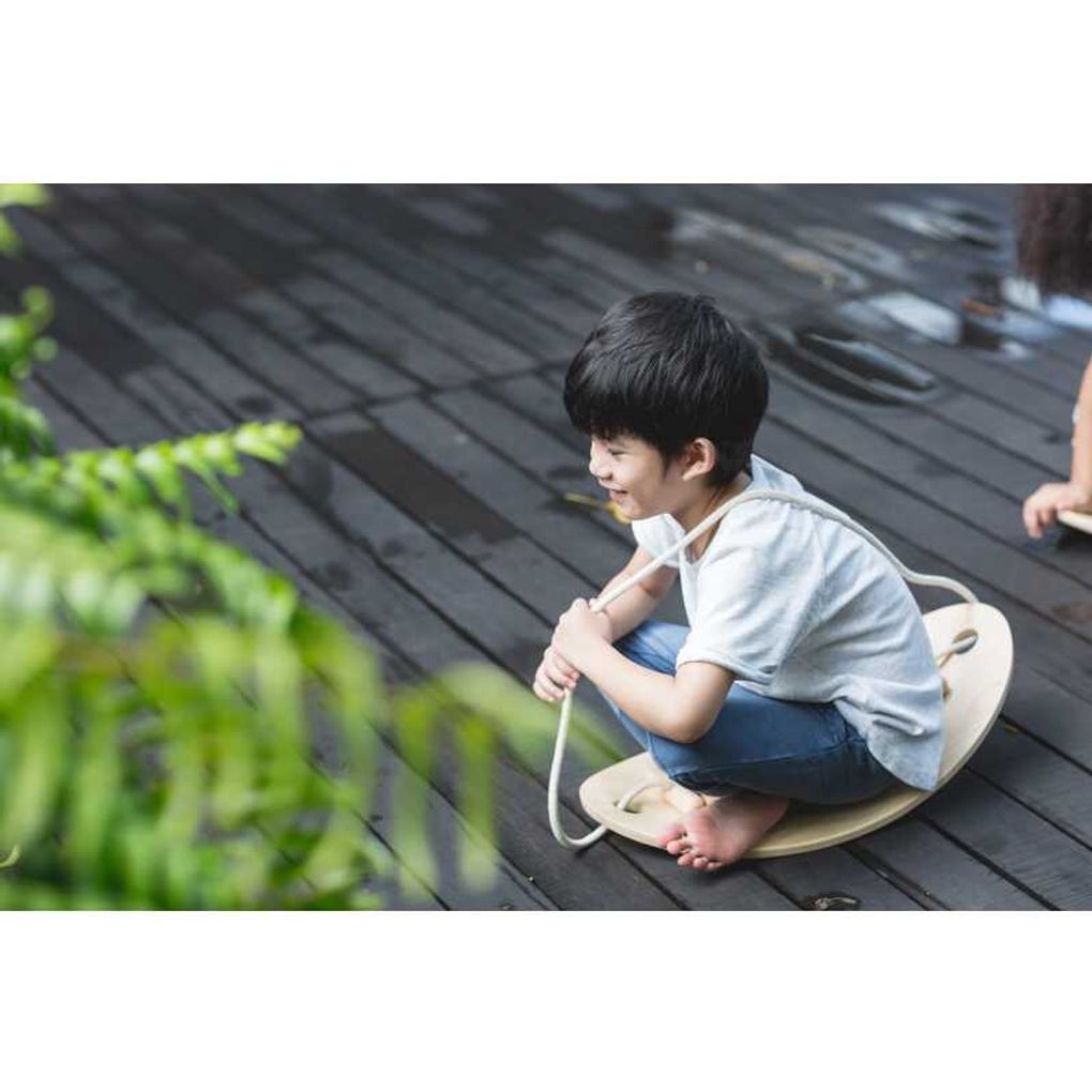Kid playing PlanToys Balance Board เด็กกำลังเล่นกระดานทรงตัวแปลนทอยส์