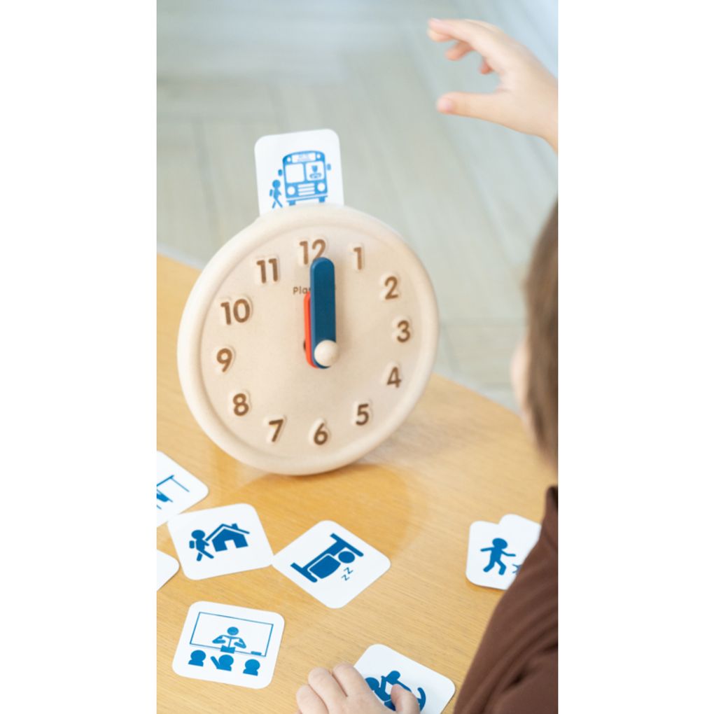 Kid playing PlanToys Activity Clock เด็กกำลังเล่นนาฬิกากิจวัตรประจำวันแปลนทอยส์